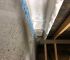 protected timber struts against cement/block wall