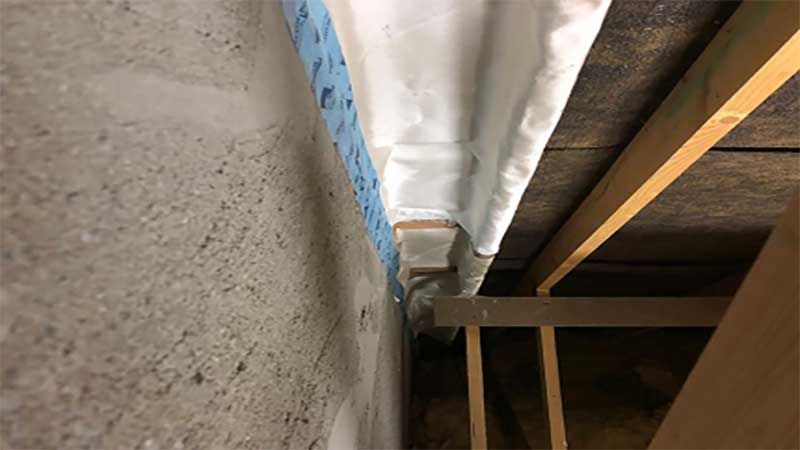 protected timber struts against cement/block wall